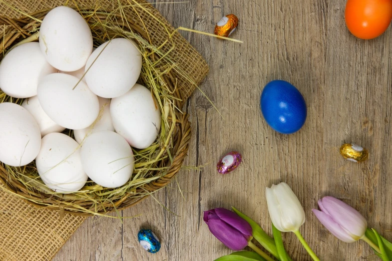 a basket filled with eggs sitting on top of a wooden table, a portrait, pexels, photorealism, tulips, candy decorations, high angle close up shot, with a white