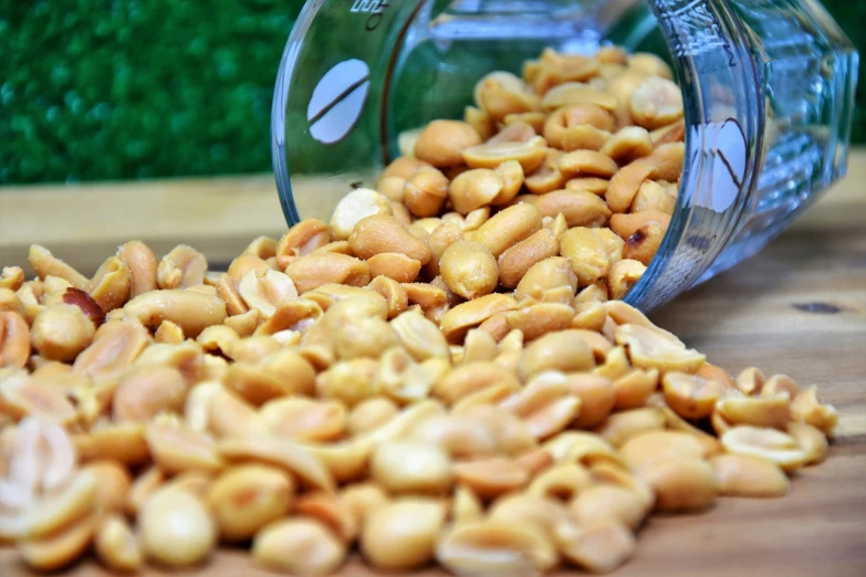 a jar filled with peanuts sitting on top of a wooden table, by Basuki Abdullah, hurufiyya, close-up product photo, bowl, long thick shiny gold beak, high detail product photo