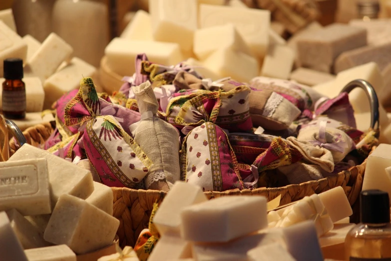 a basket filled with lots of different types of soap, figuration libre, greek fabric, closeup at the food, coconuts, white and purple