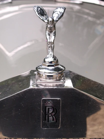 a close up of a hood ornament on a car, an art deco sculpture, by Robert Koehler, renaissance, shiny silver armor engraved, bangalore, high detail iconic character, wraith