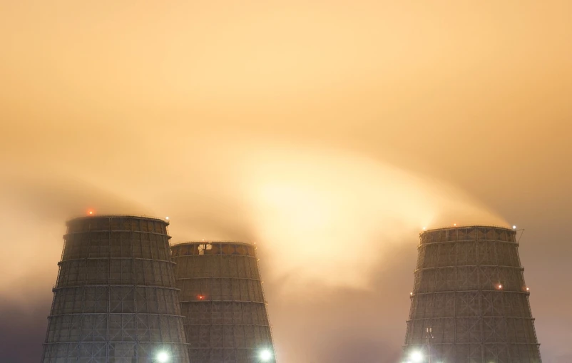 a couple of cooling towers sitting next to each other, a portrait, by Etienne Delessert, orange fog, night photo, sergey zabelin, a close-up