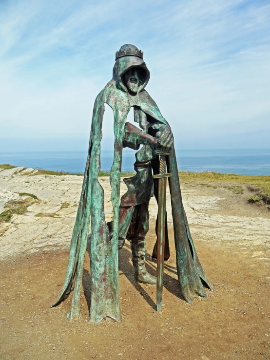 a statue of a man holding a sword, a bronze sculpture, by Edward Corbett, cornwall, worn traveling cloak, kvothe from name of the wind, artistic interpretation