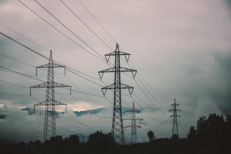 a group of power lines on a cloudy day, pexels, ivan shishk, pillars, hazy and dreary, flowing with dark power