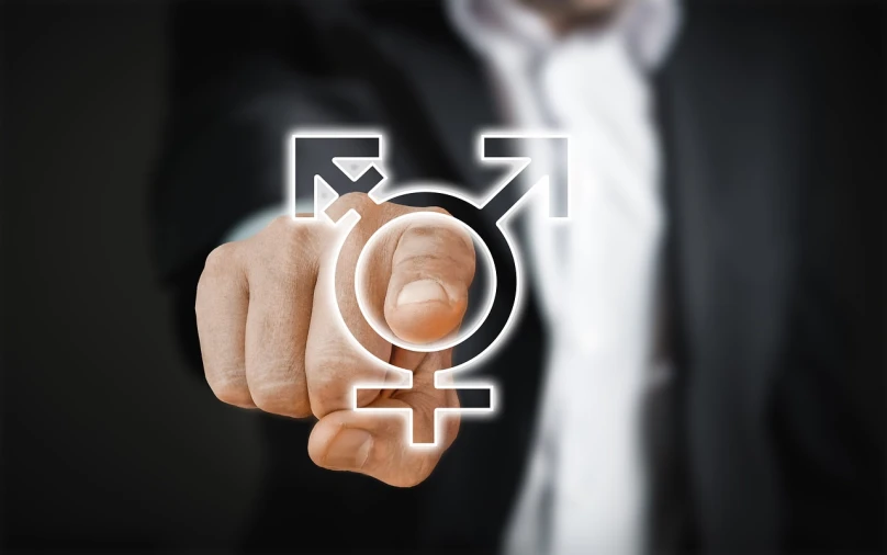 a man in a suit pointing at a male symbol, a digital rendering, by Julian Allen, pixabay, feminist art, transgender, woman his holding a sign, older male, high quality screenshot