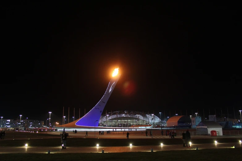 a group of people walking around an airport at night, a picture, inspired by Vladimir Borovikovsky, flickr, hurufiyya, holding a torch, stadium setting, azamat khairov, tear drop