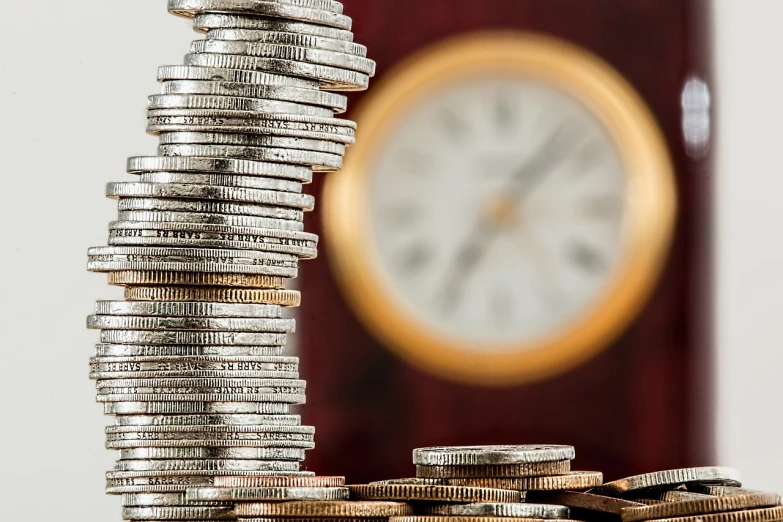 a stack of coins with a clock in the background, a photo, pixabay, background image, cash on a sidetable, up close picture, seen from below