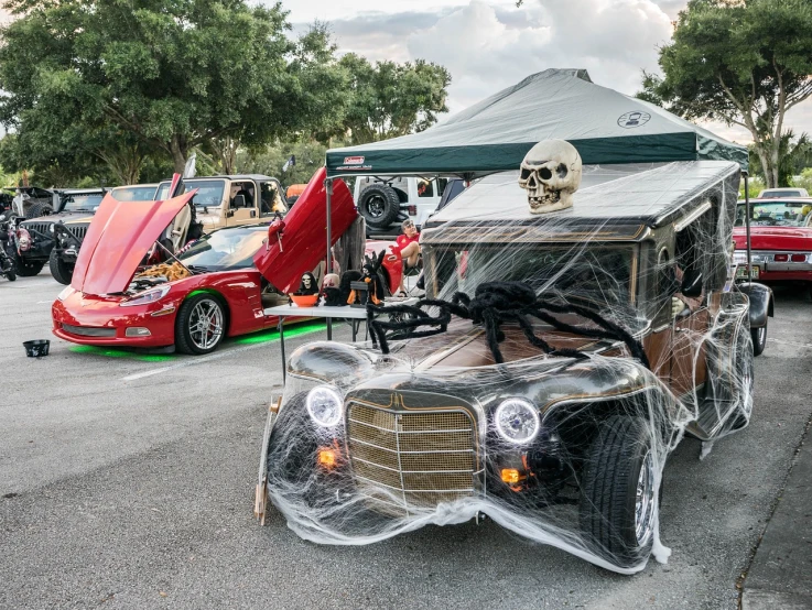 a car covered in plastic sitting in a parking lot, by Arnie Swekel, featured on reddit, lowbrow, halloween celebration, the munster in the background, frontshot, usa-sep 20