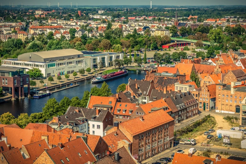 a river running through a city next to tall buildings, a photo, by Sebastian Spreng, shutterstock, in legnica!!!, red roofs, harbor, dutch camera view