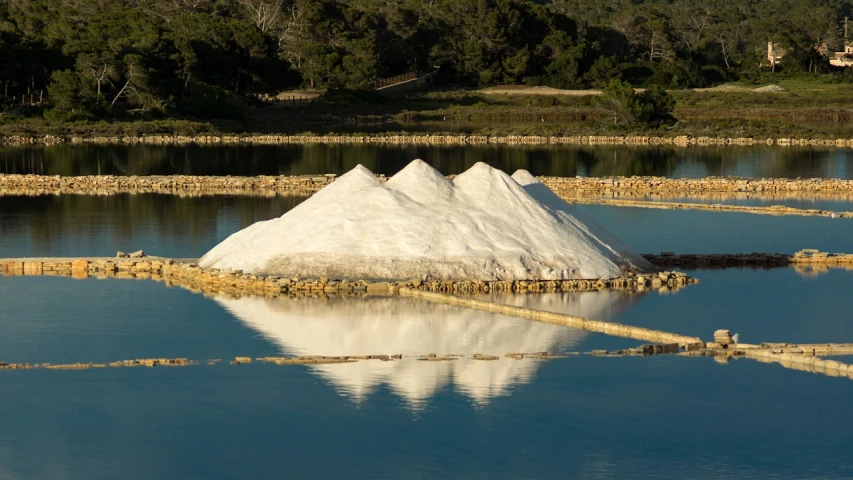 a large pile of salt sitting on top of a lake, by Nathalie Rattner, ibiza, wikimedia commons, reflective light, very award - winning