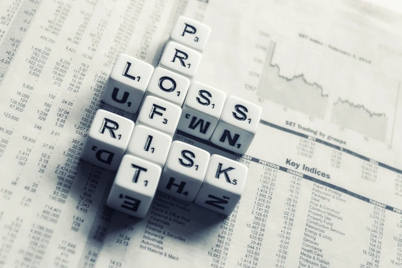 a pile of dice pieces sitting on top of a newspaper, a photo, by Kurt Roesch, shutterstock, graffiti, currency symbols printed, lord loss, word, analysis report