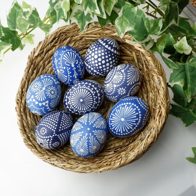 a basket filled with blue and white painted eggs, by Maksimilijan Vanka, folk art, high quality product photo, intricately carved, navy-blue, stylised design