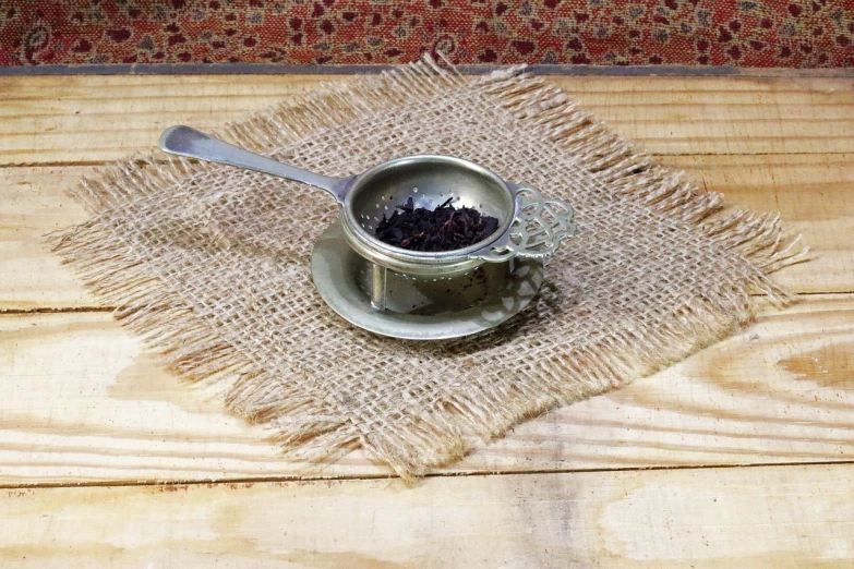 a cup of tea sitting on top of a wooden table, folk art, made of ferrofluid, burlap, hibiscus, listing image