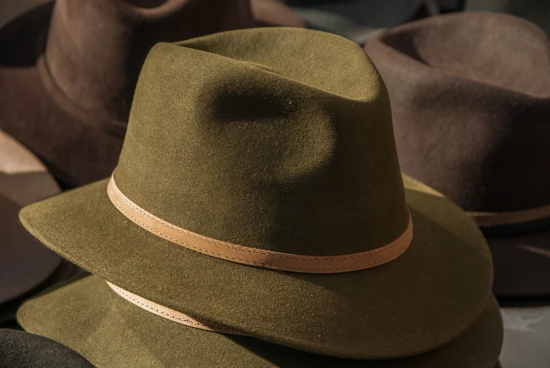 a group of hats sitting on top of a table, a macro photograph, green and brown tones, very sharp and detailed image, deerstalker, highly detailed product photo