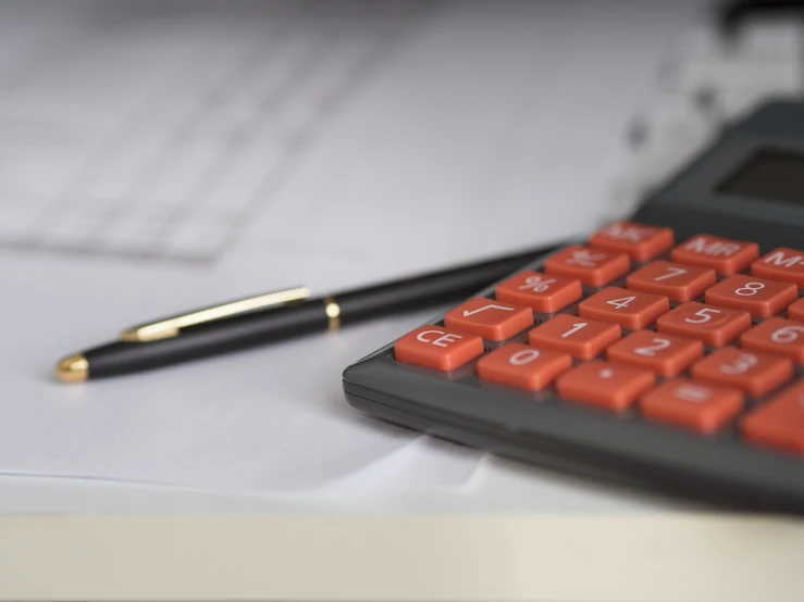 a calculator sitting on top of a desk next to a pen, a picture, fine details. red, professional closeup photo, black and red scheme, orange details