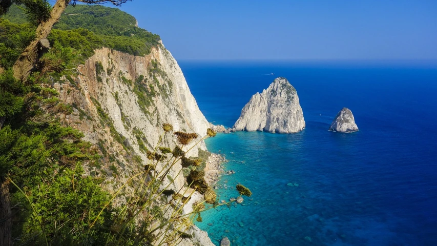 a large body of water next to a cliff, a picture, by Alexander Fedosav, shutterstock, alexandros pyromallis, two medium sized islands, piroca, steep cliffs