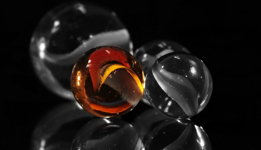 a group of glass marbles sitting on top of a table, a macro photograph, by Tom Carapic, crystal cubism, black and orange, wallpaper hd, black and white and red, amber