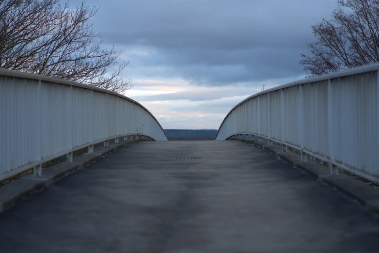 a bridge over a parking lot on a cloudy day, postminimalism, looking into the horizon, wide shot photo