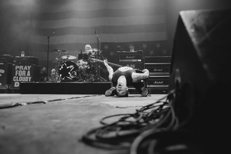 a person doing a handstand on a stage, a portrait, by Kurt Trampedach, slayer, patriot, shot on leica, laying down