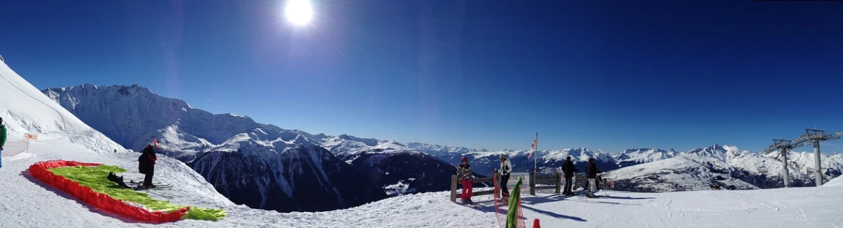 a group of people standing on top of a snow covered slope, flickr, les nabis, beautiful sunny day, 💋 💄 👠 👗, helmet view, the panorama