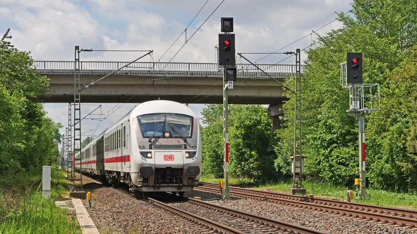 a large long train on a steel track, by Hans Schwarz, flickr, train station in summer, hsv, flashing lights, on a bright day