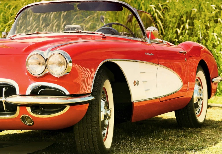 a red and white car sitting on top of a grass covered field, by Wayne England, trending on pixabay, photorealism, corvette c2 1969, vintage colours 1 9 5 0 s, front closeup, superb detail 8 k