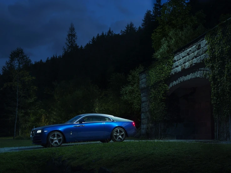 a blue rolls royce parked in front of a tunnel, by Andrei Kolkoutine, renaissance, in the woods at night, wraith, summer morning, photographic render