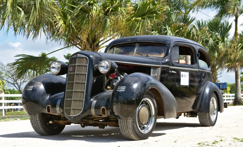 an old car is parked on the side of the road, bahamas, ebay photo, insane detail, black car