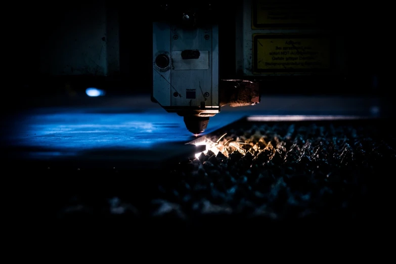 a close up of a machine cutting a piece of metal, by Matthias Weischer, pexels, holography, night time footage, blog-photo, factory floor, panels