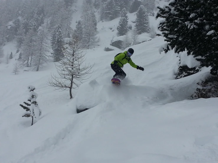 a man riding a snowboard down a snow covered slope, a picture, by Anna Haifisch, flickr, !female, blizzard in the mountains, in the dolomites, palm