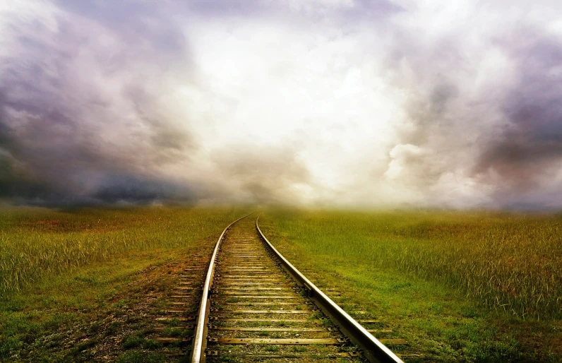 a train track in the middle of a grassy field, a picture, by Alison Geissler, shutterstock, minimalism, magical storm fog, vertical wallpaper, curved perspective, made with photoshop