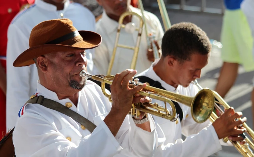 a man in a hat playing a trumpet, pexels, white uniform, caribbean, focus on the musicians, 2070