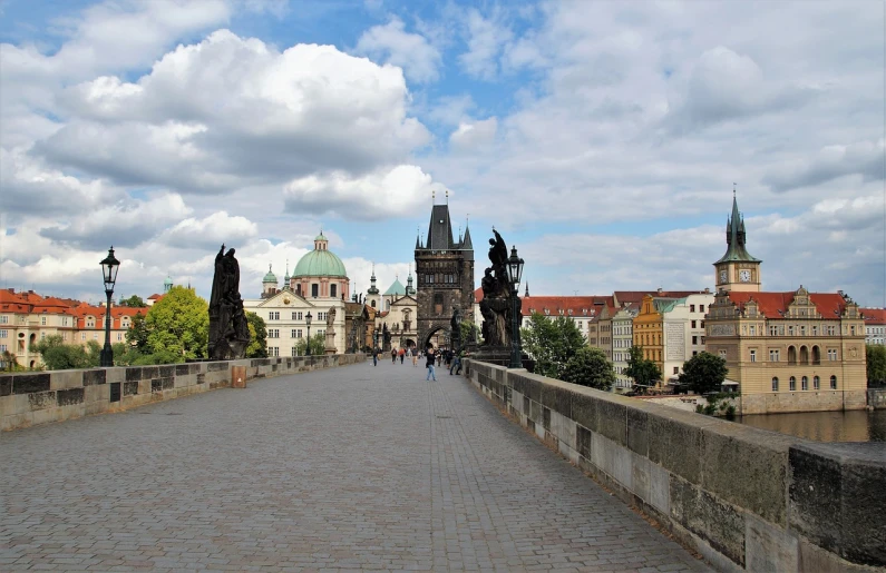 a group of people walking across a bridge, by Sigmund Freudenberger, shutterstock, baroque, prague, long view, three towers, stone