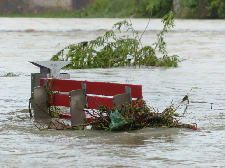 a red bench sitting in the middle of a flooded street, hurufiyya, damaged vine bridge, full res, video, janusz kaminski