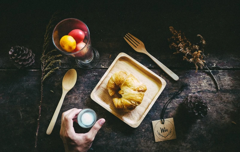 a person sitting at a table with a plate of food, a still life, unsplash, in a wooden box. top down photo, retro dark vintage, holding a lantern, breakfast