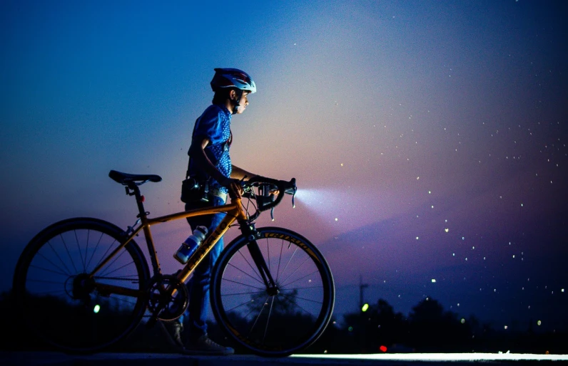 a man that is standing next to a bike, by Jan Rustem, pexels, realism, glow around helmet, transparent celestial light gels, sport, looking to stars