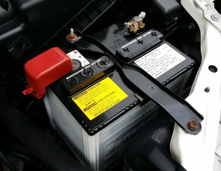 a close up of a car battery in a vehicle, a picture, by Adam Szentpétery, shutterstock, black and yellow and red scheme, [ realistic photo ]!!, in australia, photo taken with an iphone