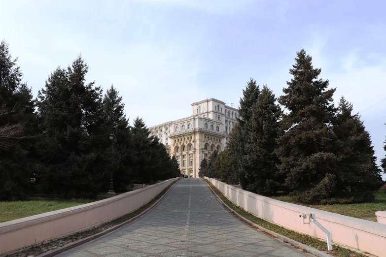 a large building sitting on the side of a road, inspired by György Rózsahegyi, renaissance, view from front, pov photo, park, front photo