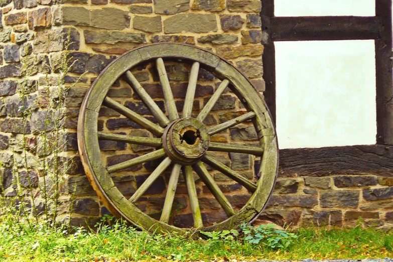 a wagon wheel leaning against a stone building, by Hans Schwarz, renaissance, wooden, closeup photo, panzer, canvas