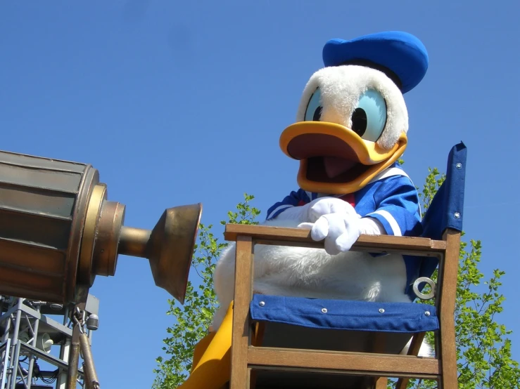 a large stuffed duck sitting on top of a wooden chair, a picture, flickr, disney character, inauguration, in an action pose, [ closeup ]!!