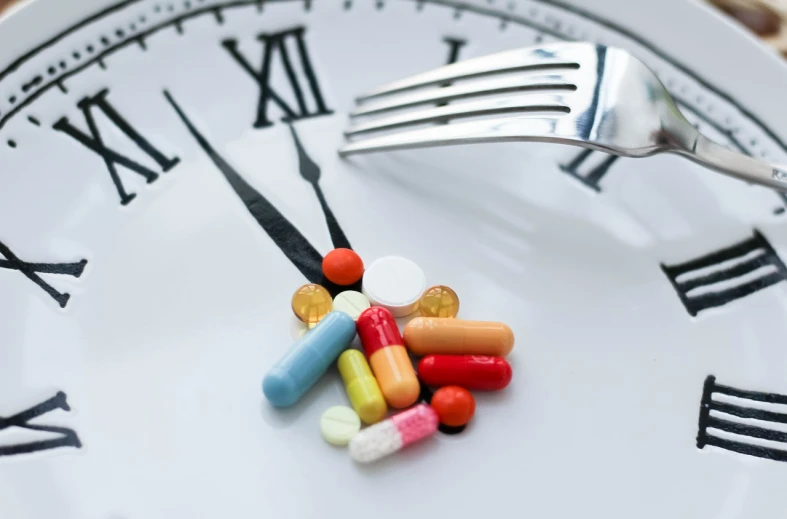 a white plate topped with pills and a fork, a digital rendering, by Matija Jama, shutterstock, antipodeans, mechanical clock, countdown, an ultrafine detailed photo, full color still