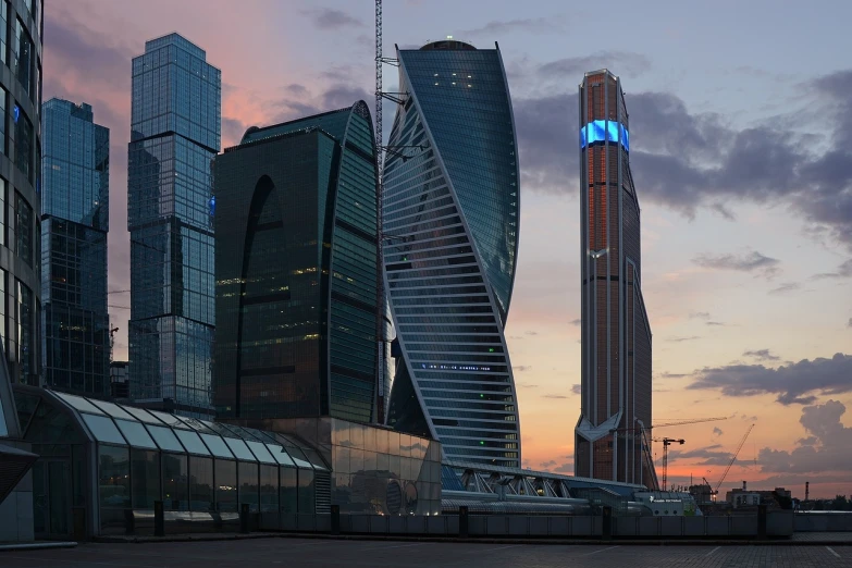 a train traveling through a city next to tall buildings, a detailed matte painting, by Fyodor Rokotov, hypermodernism, blue hour, kremlin, sins inc skyscraper front, curvy build