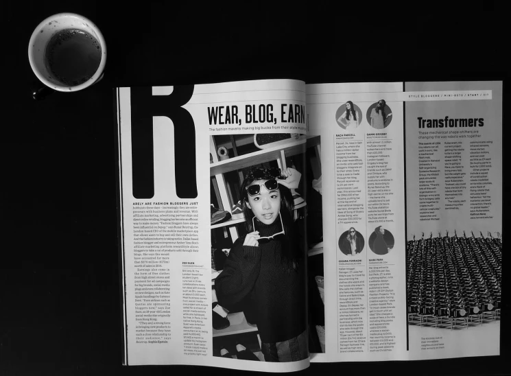 a coffee cup sitting on top of a table next to a magazine, a black and white photo, by Ceri Richards, featured on tumblr, letterism, photograph of a techwear woman, black bangs, esrb, wong kar wai