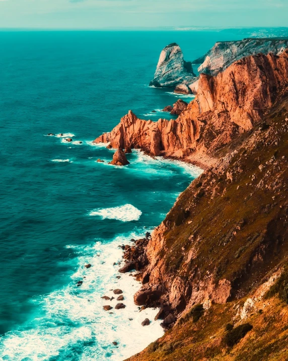 a view of the ocean from the top of a hill, by Alexander Bogen, pexels contest winner, realism, ocher and turquoise colors, cliffs, post processed 4k, portugal