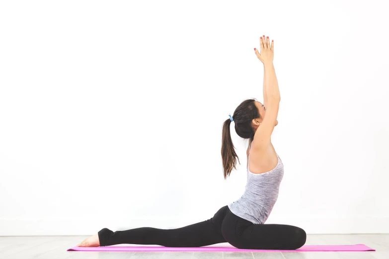 a woman doing a yoga pose on a pink mat, shutterstock, half body photo