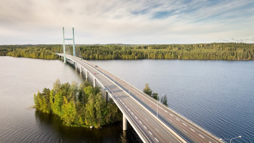 a long bridge over a large body of water, by Eero Järnefelt, shutterstock, roads, swedish urban landscape, high - angle view, northern finland