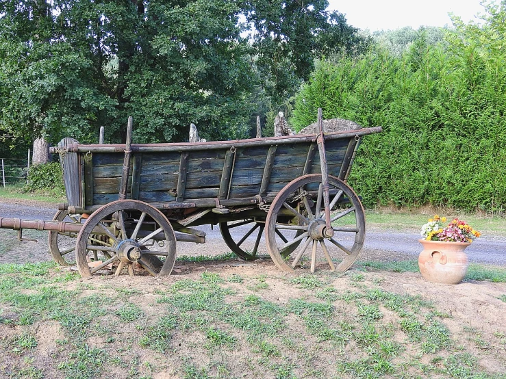 a wooden wagon sitting on top of a grass covered field, a photo, renaissance, traveling in france, antiques, outside view, très détaillé