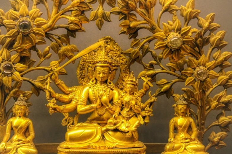 a gold statue sitting on top of a table, a statue, cloisonnism, golden sacred tree, indian temple, intricate and beautiful details, displayed on the walls