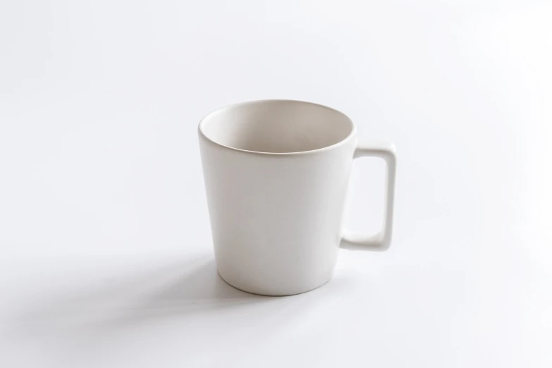 a white cup sitting on top of a table, by Shigeru Aoki, high detail product photo, productphoto, straight neck, ello