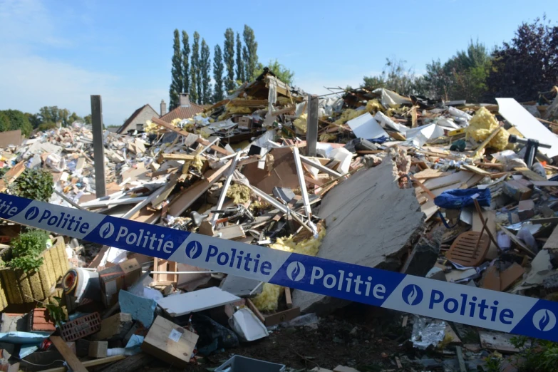 a pile of rubble sitting next to a street sign, by Schelte a Bolswert, plasticien, huge smashed mansion, afp, police tape, hyacinthe rigaurd