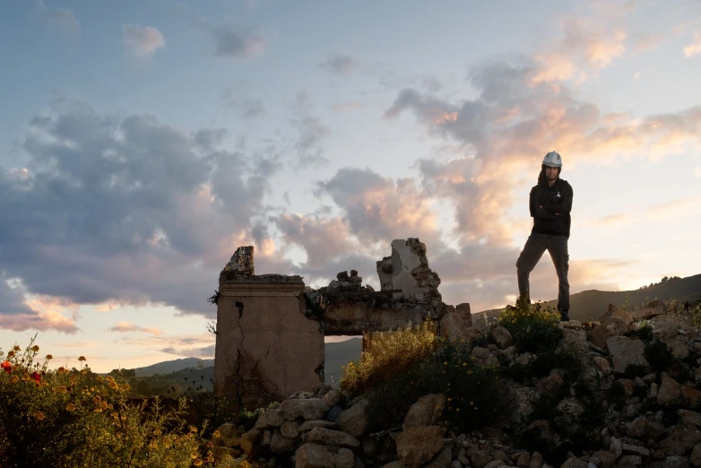 a man standing on top of a pile of rocks, a portrait, by Dietmar Damerau, in ruin agora of athens sunset, derelict house, panoramic photography, california;